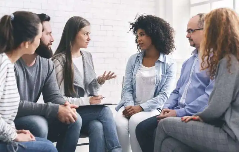Foto de várias pessoas reunidas discutindo algo.